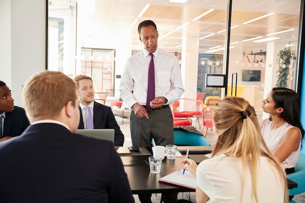 Gerente masculino negro abordando colegas em uma reunião