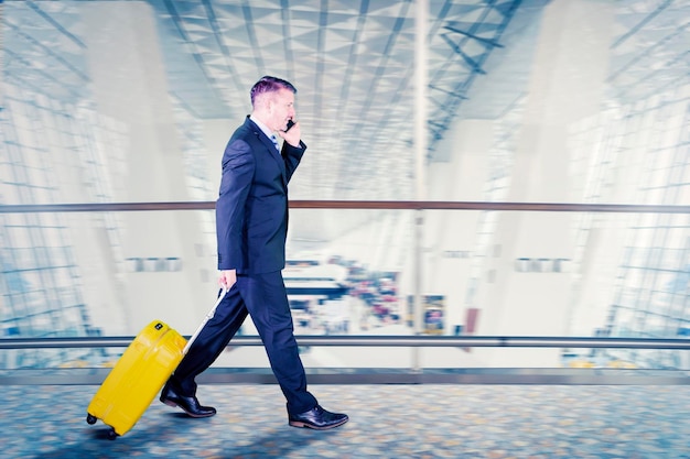 El gerente masculino ocupado hace una llamada telefónica en el aeropuerto