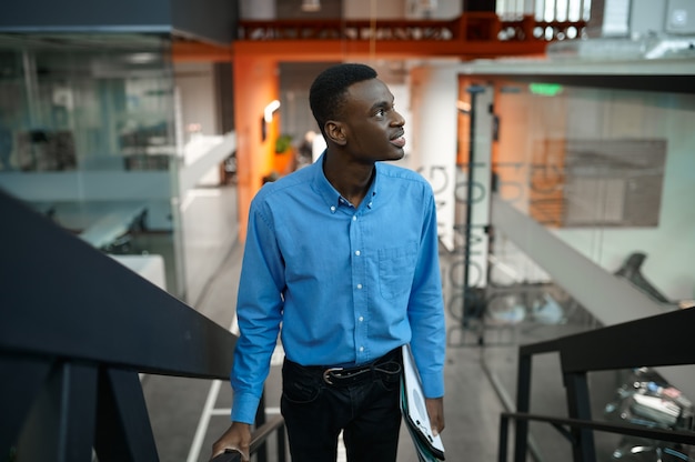 Gerente masculino pensativo en las escaleras, idea en desarrollo en la oficina de TI. Trabajador profesional, planificación o lluvia de ideas. Hombre de negocios exitoso trabaja en empresa moderna