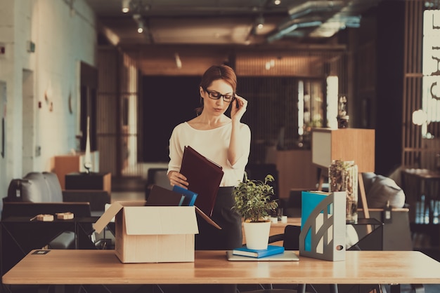 Gerente mujer está poniendo las cosas en el lugar de trabajo.