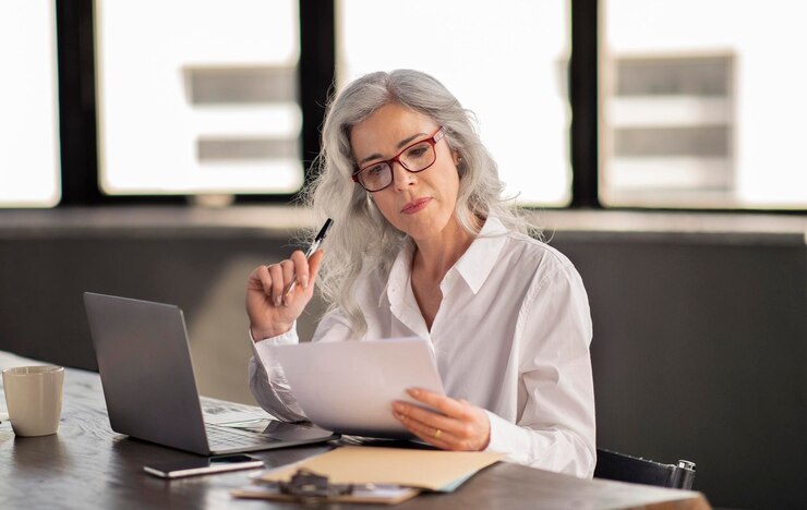 Gerente mujer leyendo candidato cv sosteniendo papel en la oficina moderna