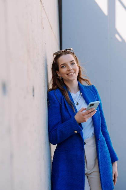 Gerente de mujer mirando a la cámara con copyspace de teléfono inteligente aislado foto de alta calidad