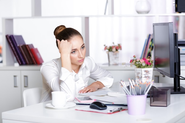 Gerente mulher cansada no escritório após um dia duro de trabalho