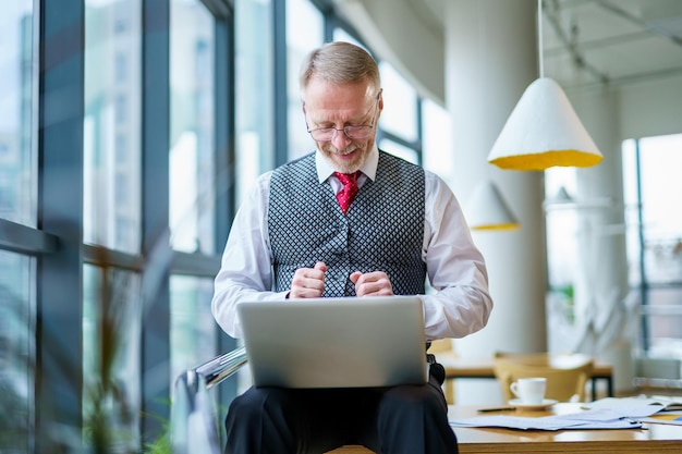 Gerente de negocios confiado trabajando con computadora portátil Hombre de negocios feliz sentado con computadora