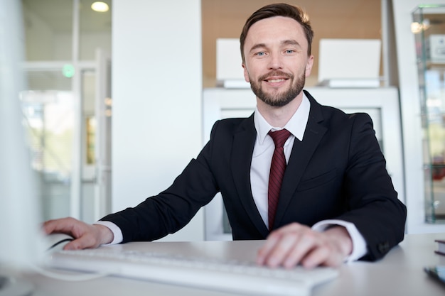 Gerente de negocios guapo en el escritorio