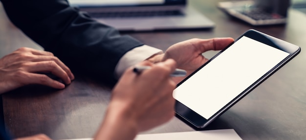 Gerente de negocios con pantalla en blanco de tableta y reunión en la mesa en la oficina.