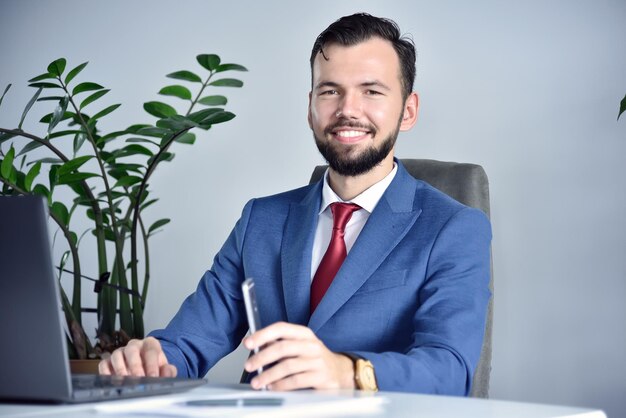 Gerente de oficina feliz con teléfono inteligente en la mano