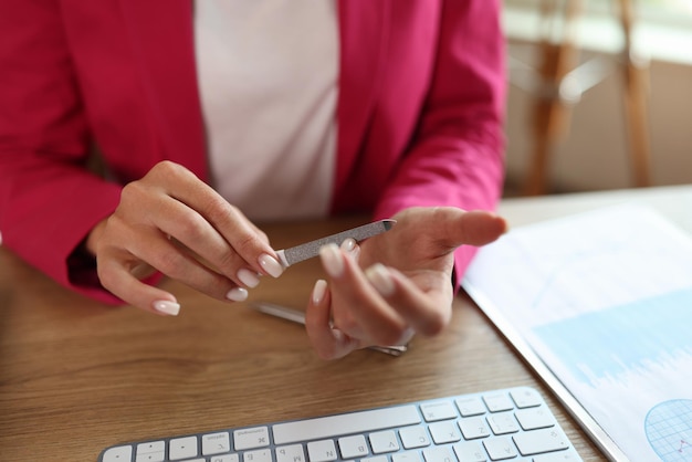 Gerente de oficina femenina limando sus uñas en la oficina