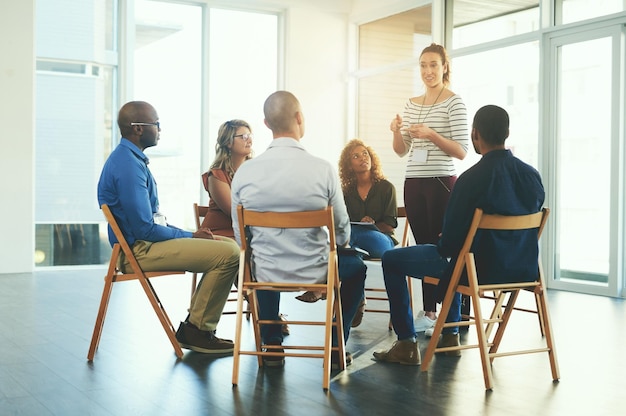 Gerente ou CEO feminino falando em uma reunião de trabalho em equipe sobre desenvolvimento e sucesso de equipe Grupo de equipe de marketing falando sobre uma estratégia de trabalho juntos em um seminário de treinamento ou treinamento em uma empresa