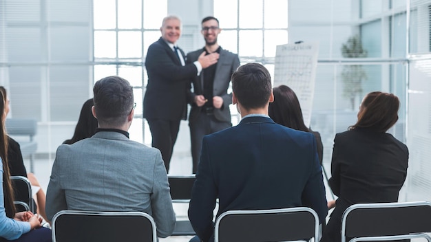 Gerente parabenizando o melhor funcionário em reunião com a equipe de negócios.