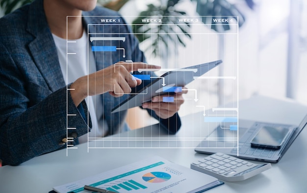 Gerente de proyecto trabajando y actualizando tareas con hitos, planificación de progreso y diagrama de programación de diagramas de Gantt, tranvía comercial trabajando en la oficina