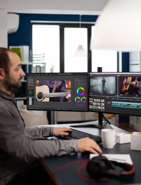 Foto gerente de proyecto de video de edición de producción que trabaja en la puesta en marcha de la oficina de la agencia creativa en la pc con dos monitores