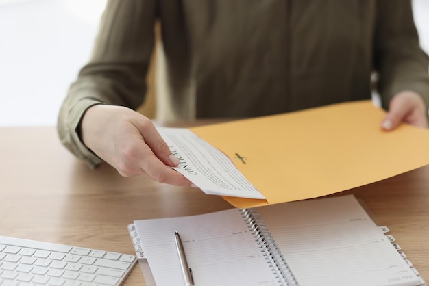 La gerente recibió un contrato por correo mientras estaba sentada en la secretaria de la oficina y pone un acuerdo en