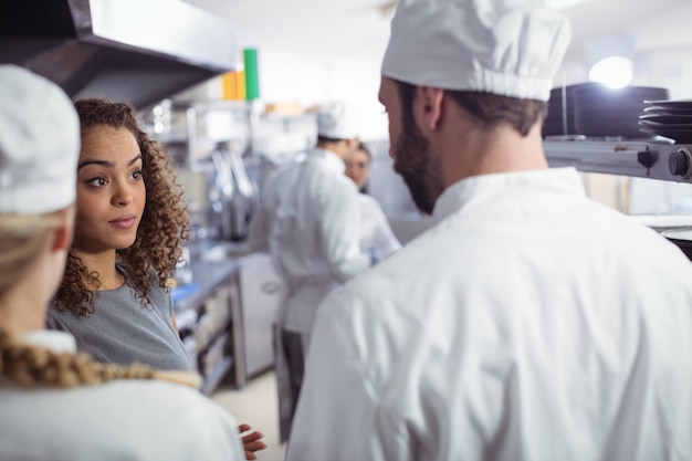 Foto gerente de restaurante interactuando con su personal de cocina