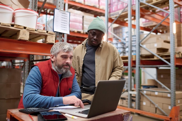 Gerente revisando el transporte en línea en la computadora portátil