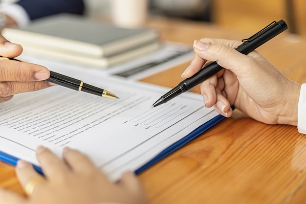 Foto el gerente señala el contrato de trabajo para que el aspirante firme como convenio de trabajo, el aspirante firma el contrato de trabajo con la empresa, el convenio salarial y las prestaciones.