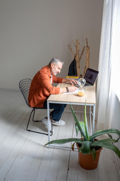 Gerente sentado à mesa no escritório e olhando pensativo