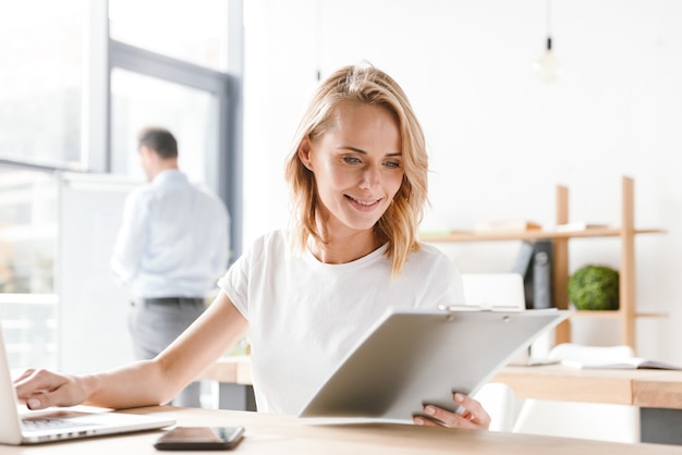 Gerente sorridente trabalhando em um laptop