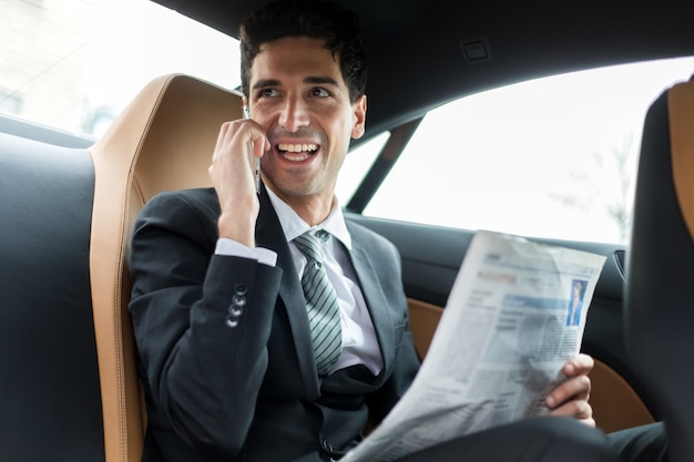 Gerente en el teléfono sentado en el asiento trasero de un coche