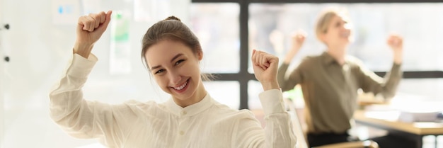 Los gerentes levantan la mano y celebran en los lugares de trabajo el concepto de victoria y