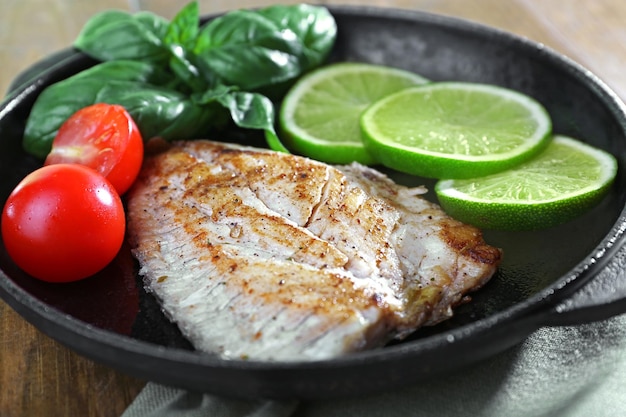 Gericht aus Fischfilet mit Salat und Limette auf dem Tisch aus nächster Nähe