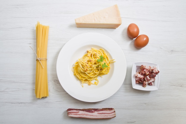 Gericht mit Carbonaras Spaghetti und Zutaten auf weißem Holz