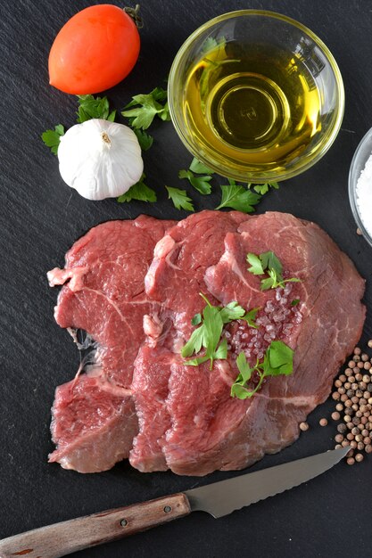 Gericht mit rohem fleisch mit salz, öl und petersilie