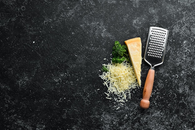 Geriebener Hartkäse auf schwarzem Steinhintergrund Parmesan Draufsicht Freier Platz für Ihren Text