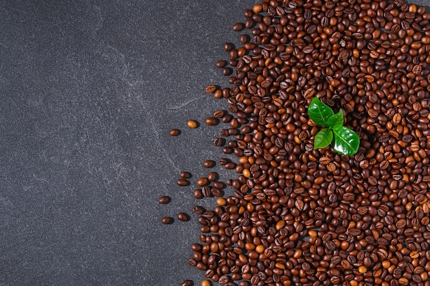 Geröstete braune Kaffeebohnen auf einer grauen Hintergrundansicht von oben