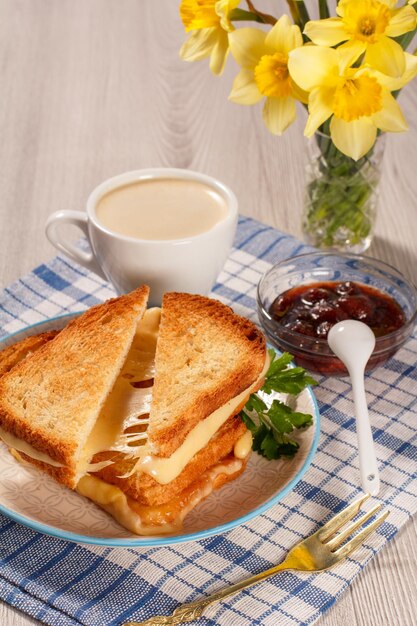 Geröstete Brotscheiben mit Käse und grüner Petersilie auf weißer Tellergabel Tasse Kaffee