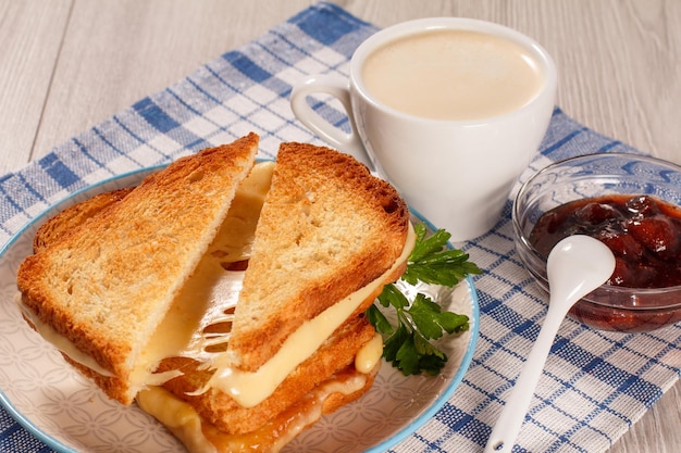 Geröstete Brotscheiben mit Käse und grüner Petersilie auf weißer Tellertasse Kaffee