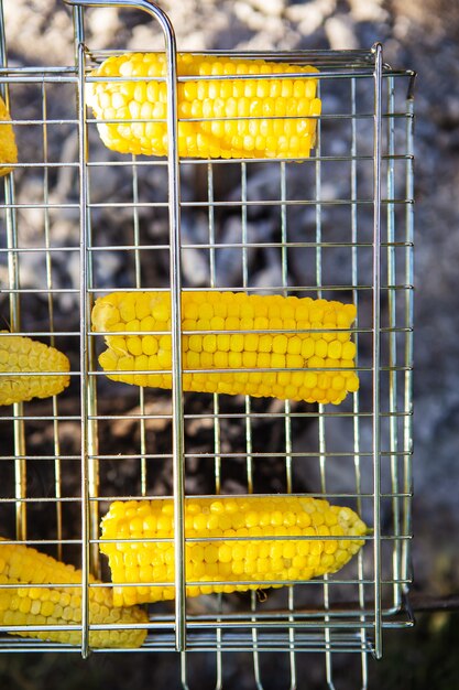 Geröstete gelbe saftige Maiskolben auf einem Drahtgestell gekocht. Wochenende, Erholung im Freien. Von oben betrachten.