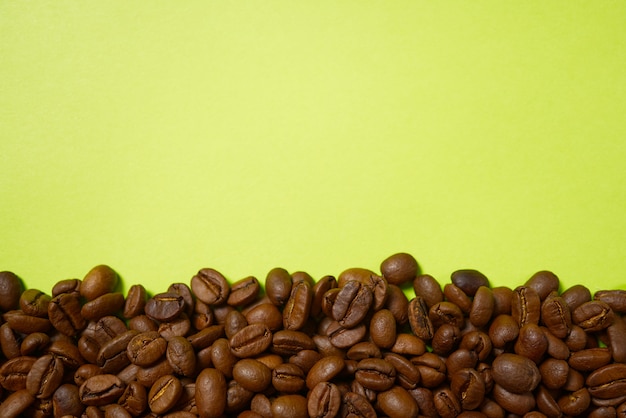 Geröstete Kaffeebohnen auf dem gelben Hintergrund.