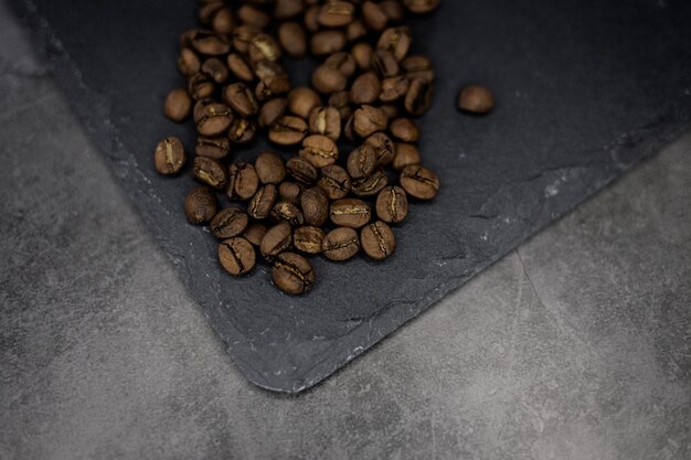Geröstete Kaffeebohnen auf einem Grunge dunklen Hintergrund Draufsicht