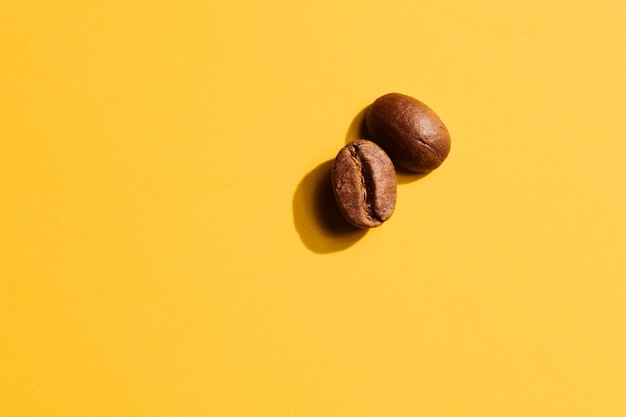 Geröstete Kaffeebohnen auf gelbem Hintergrund