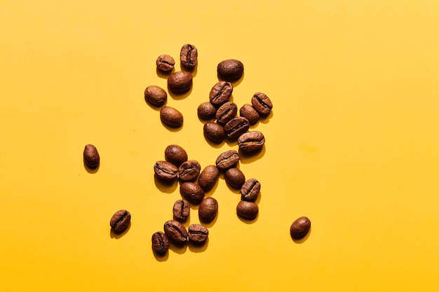 Geröstete Kaffeebohnen auf gelbem Hintergrund