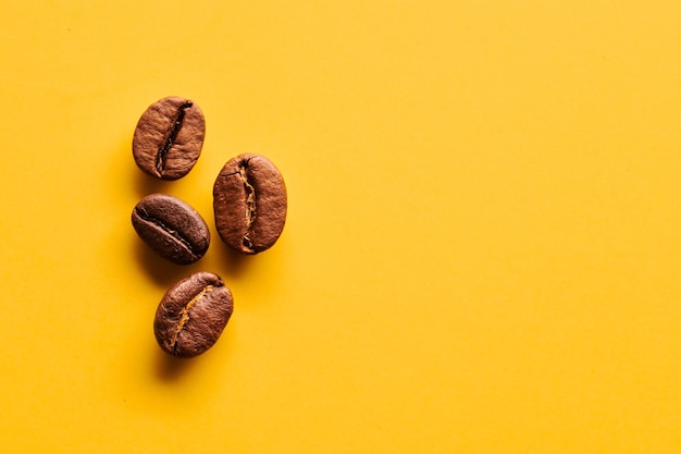 Geröstete Kaffeebohnen auf gelbem Hintergrund