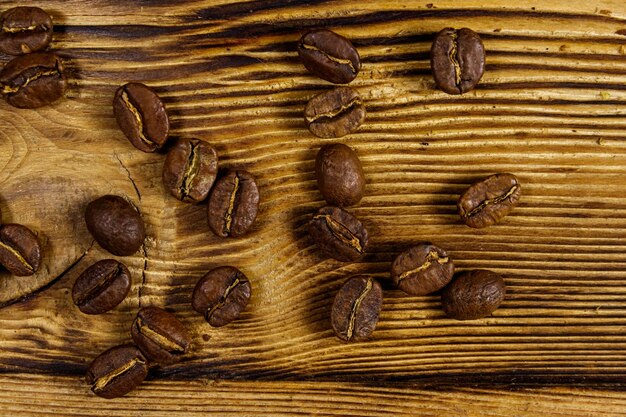 Geröstete Kaffeebohnen auf rustikalem Holztisch verstreut