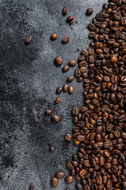 Geröstete Kaffeebohnen auf rustikalem Tisch auf schwarzem Tisch. Draufsicht.