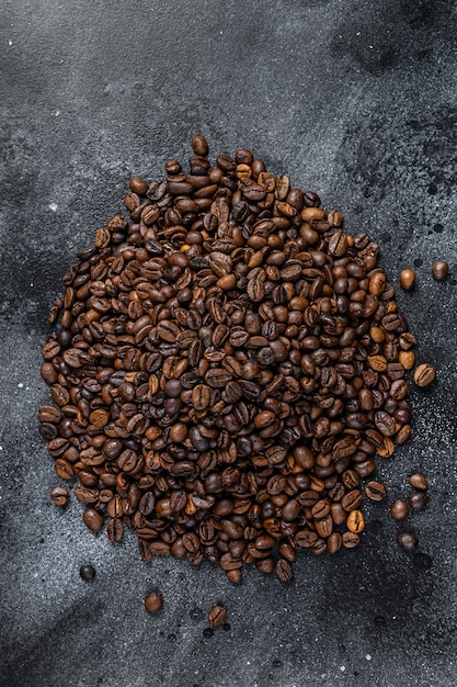 Geröstete Kaffeebohnen auf rustikalem Tisch. Schwarzer Hintergrund. Ansicht von oben.