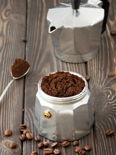 Geröstete Kaffeebohnen in einem Glas, verstreut auf einem braunen Holztisch