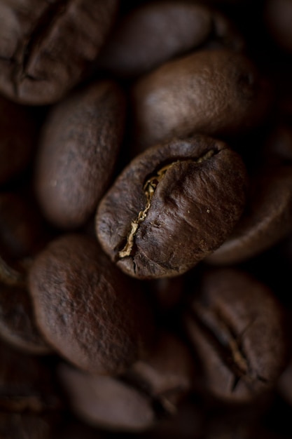 Geröstete Kaffeebohnen mit extrem nahem Hintergrund und goldenen Streifen, gutes Morgenkonzept