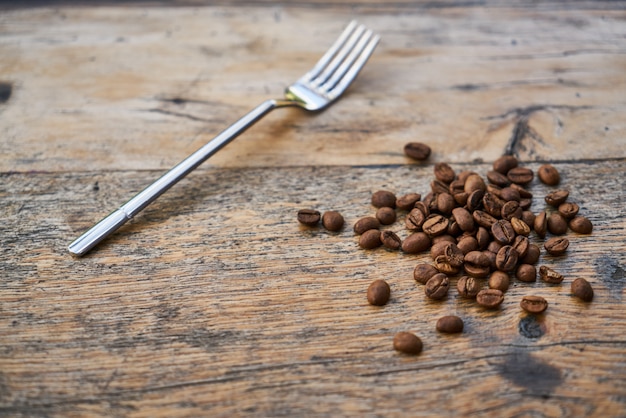 Geröstete Kaffeebohnen und Gabel auf einem Tisch