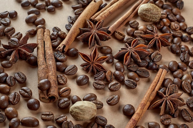 Foto geröstete kaffeebohnen zimtstangen sternanis und muskatnuss auf braunem hintergrund