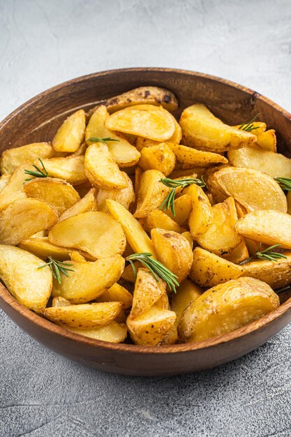 Geröstete Kartoffelspalten mit Rosmarin vegetarische Bio-Kartoffelspalten Mahlzeit Weißer Hintergrund Ansicht von oben