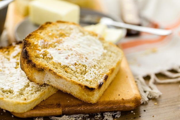 Geröstete Scheiben frisch gebackenes Sauerteigbrot mit Butter.