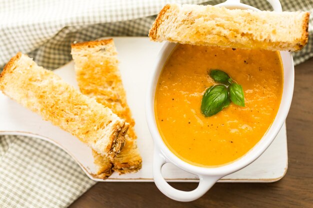 Geröstete Tomatensuppe mit Bio-Erbstücktomaten zubereitet und mit gegrilltem Käsesandwich serviert.