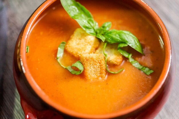 Geröstete Tomatensuppe mit frischem Basilikum und Croutons.