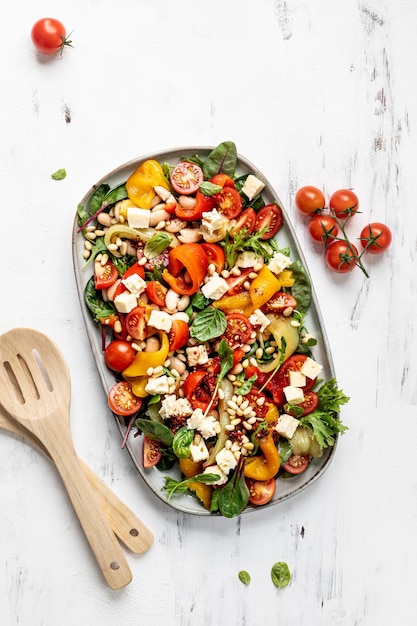 Gerösteter Pfeffer- und Butterbohlensalat mit Harissa-Dressing auf weißem Hintergrund