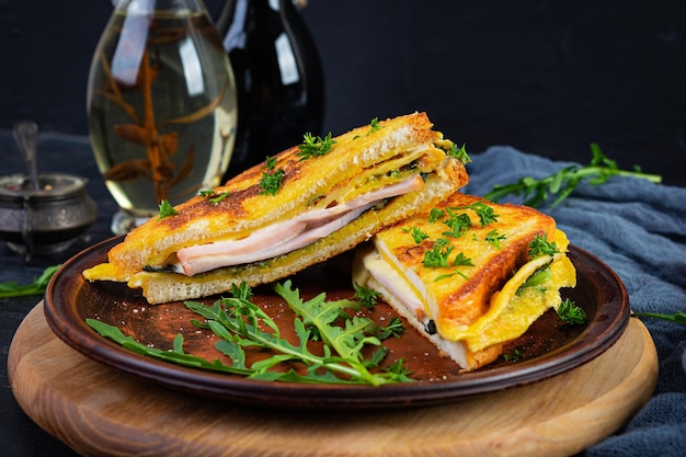 Gerösteter Toast in Rührei mit Schinkenkräutern und Käse-Cheddar Köstliches gegrilltes Frühstückssandwich